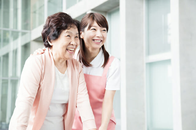 介護士が女性の高齢者を支える写真